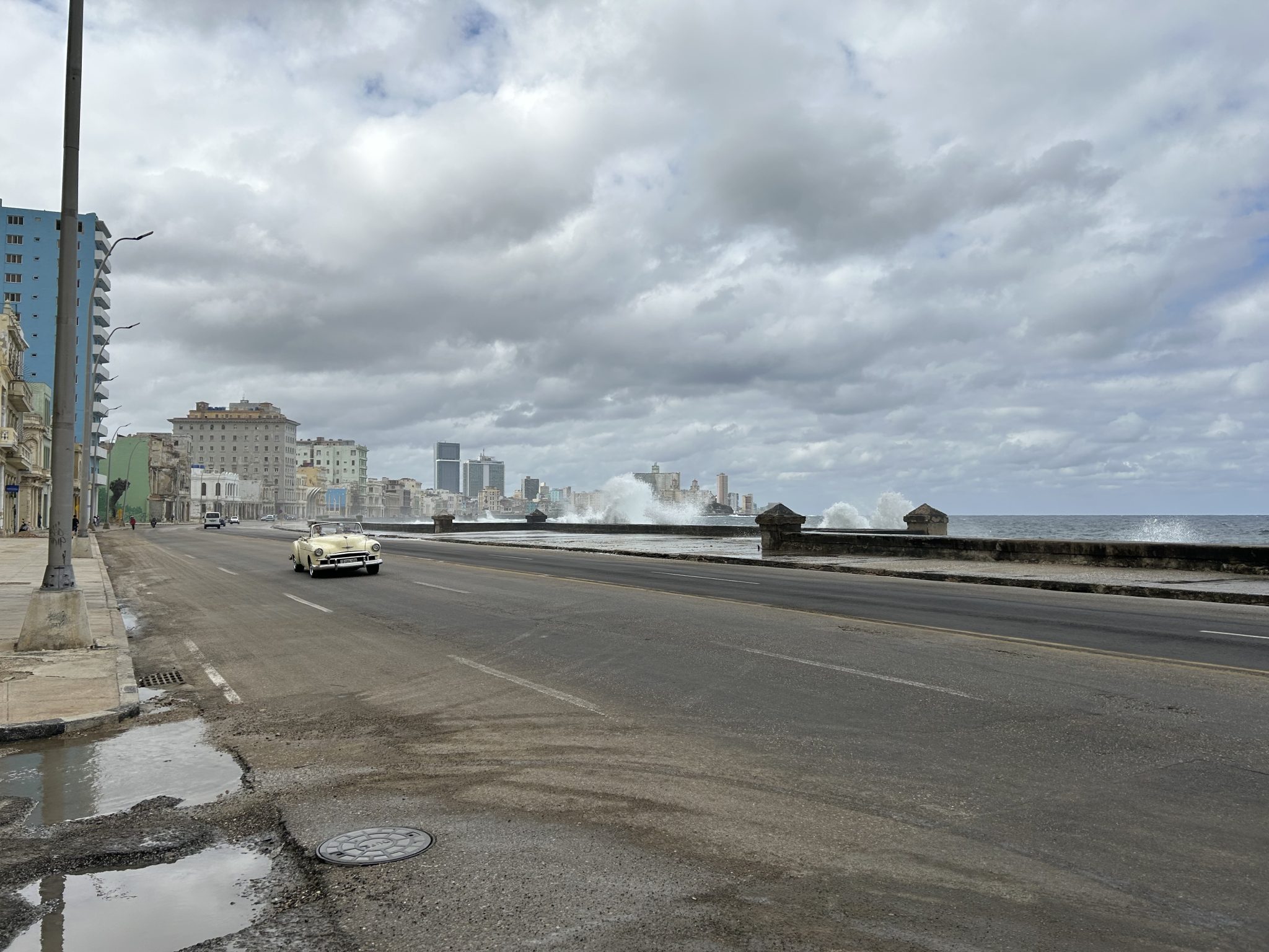 Car driving on the road by the Malecón in Havana Cuba